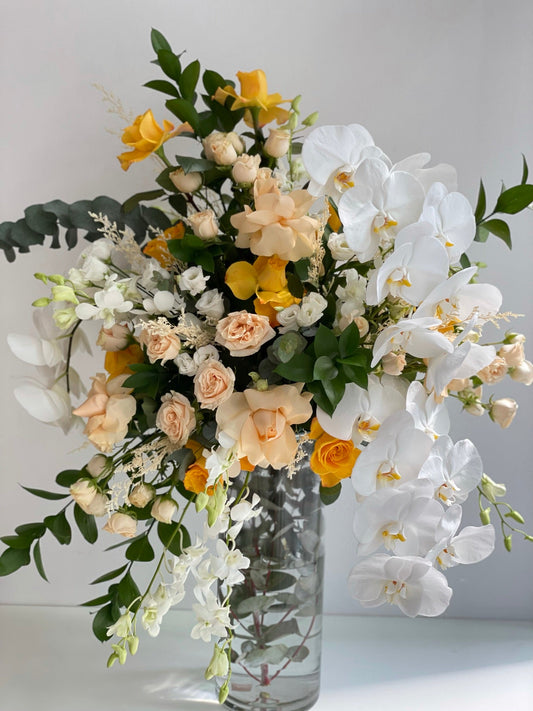 Orchids with yellow and peach roses