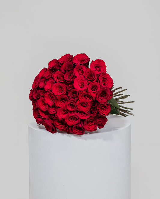A luxurious arrangement of 50 deep red roses, elegantly displayed to convey heartfelt affection and passion for Valentine's Day.