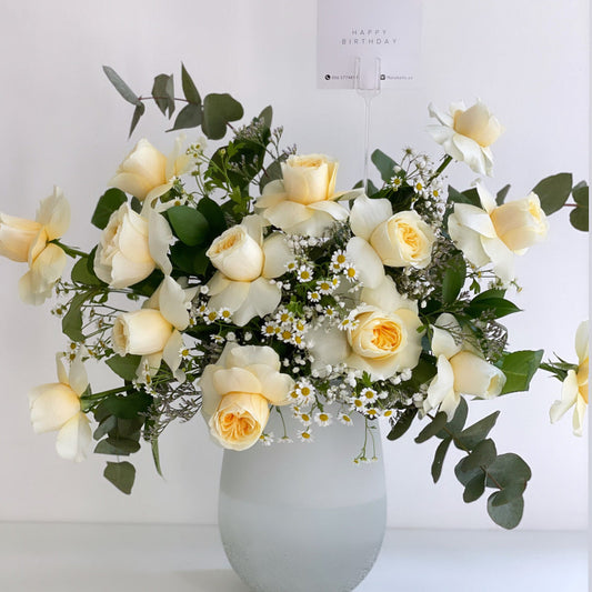 Buttercup roses and chamomile in a vase