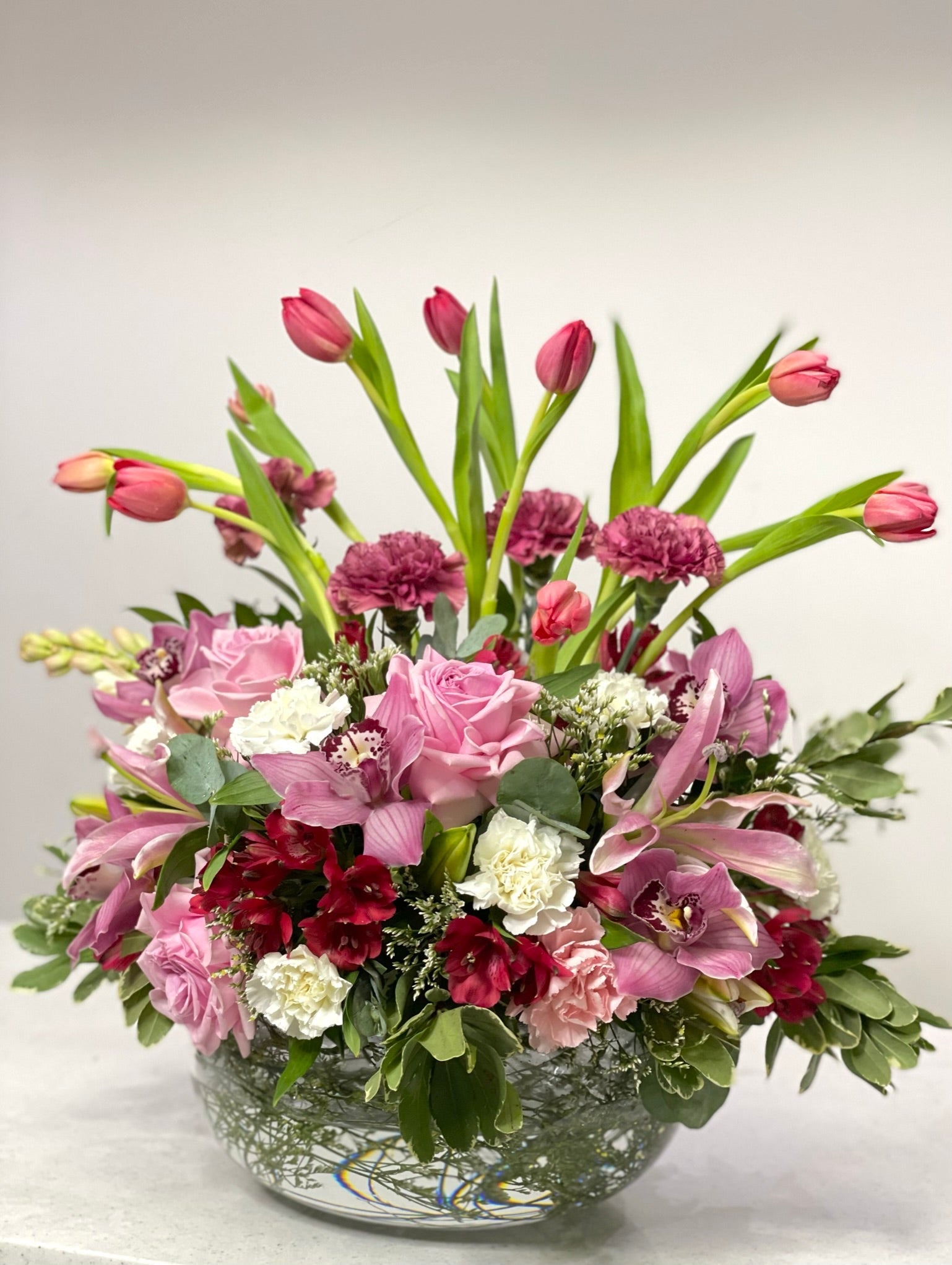 Maroon coloured flower arrangement with standing tulips