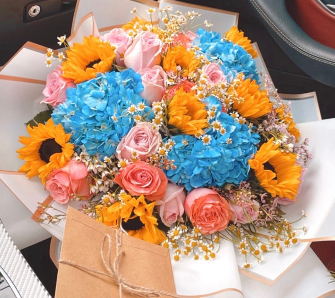 Sunflowers with blue hydrangeas, chamomile and pink roses