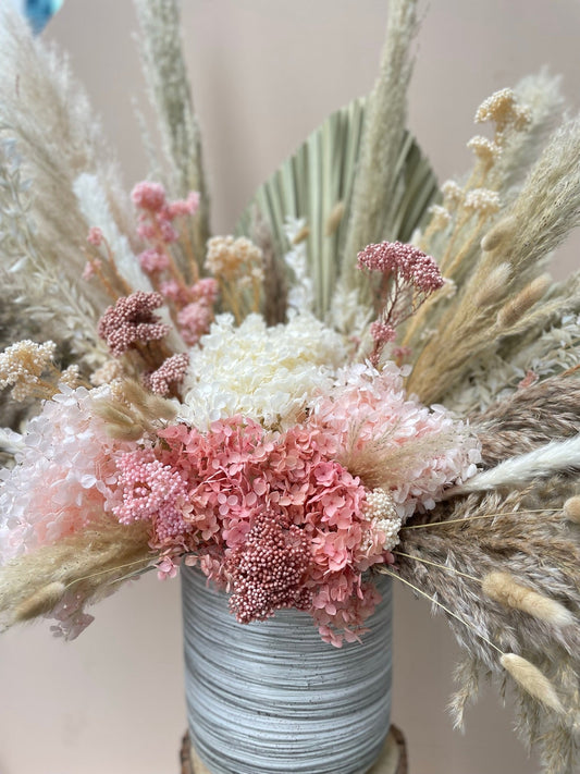 A pink and white dried flower arrangement