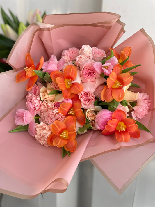 Orange tulips with pink carnations and roses