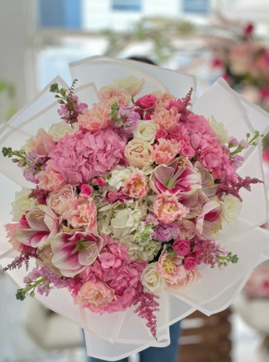 A large bouquet of mixed pink flowers, hydrangea, amaryllis, tulips, roses, carnations 