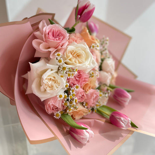 a fun combination of pink, cream and peach roses and flowers with chamomile