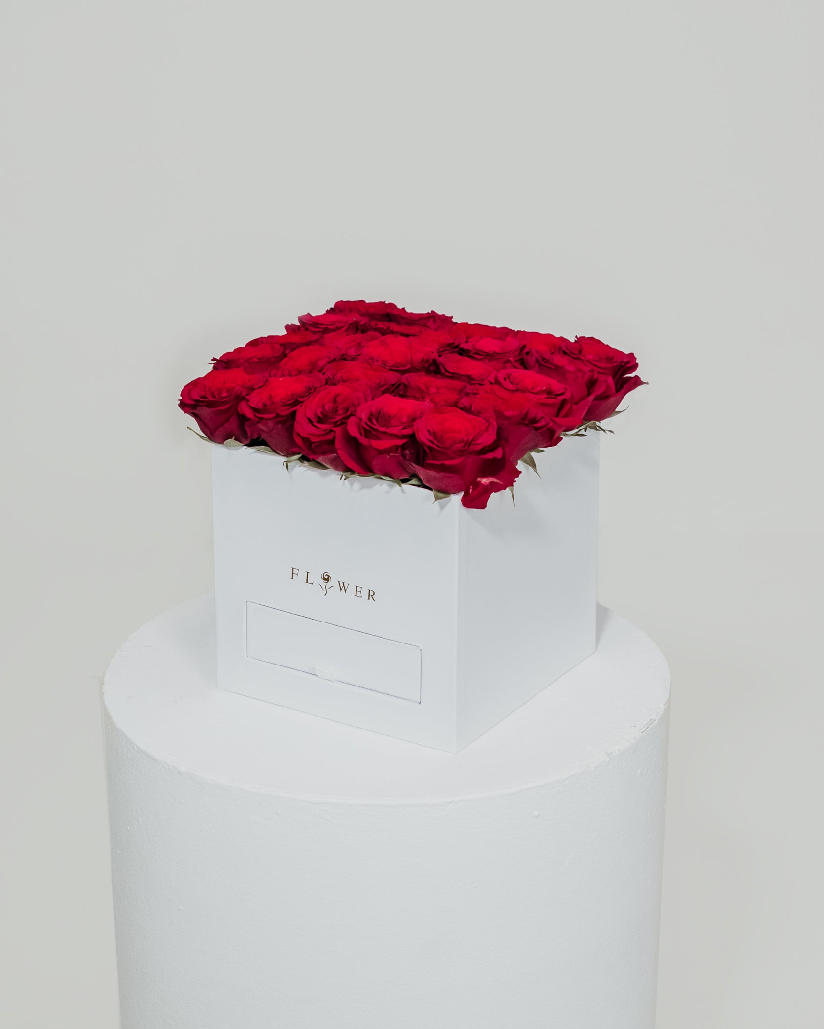 A white box filled with beautiful red roses, complemented by a drawer filled with Ferrero Rocher chocolates.